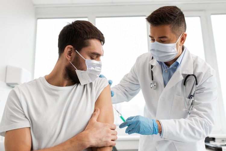 Doctor administering a vaccination to an adult patient in a clinical setting