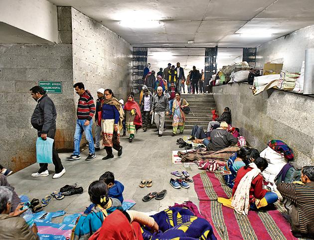 People resting and waiting inside a crowded public hospital passageway in India.